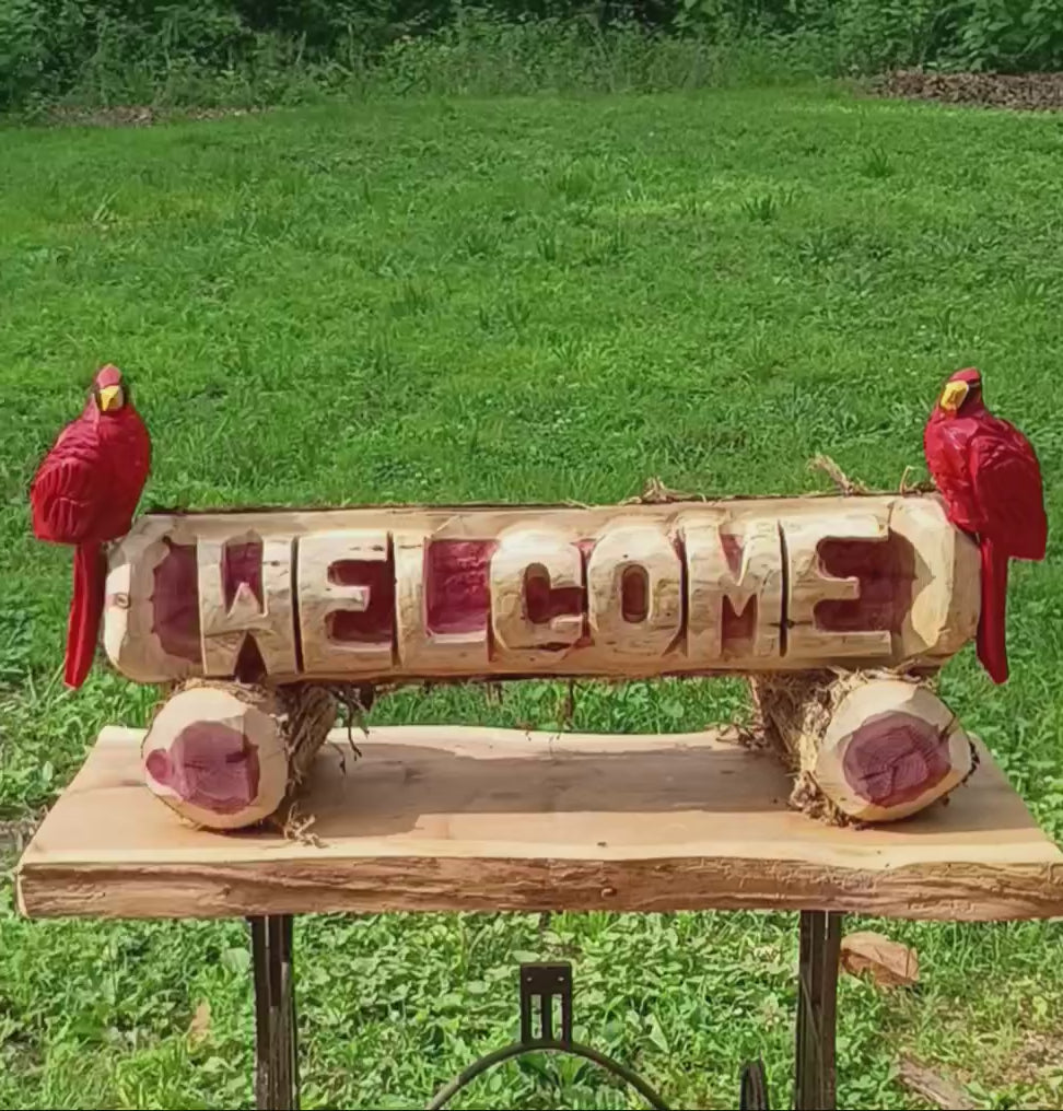Welcome log with (2) Cardinal Birds