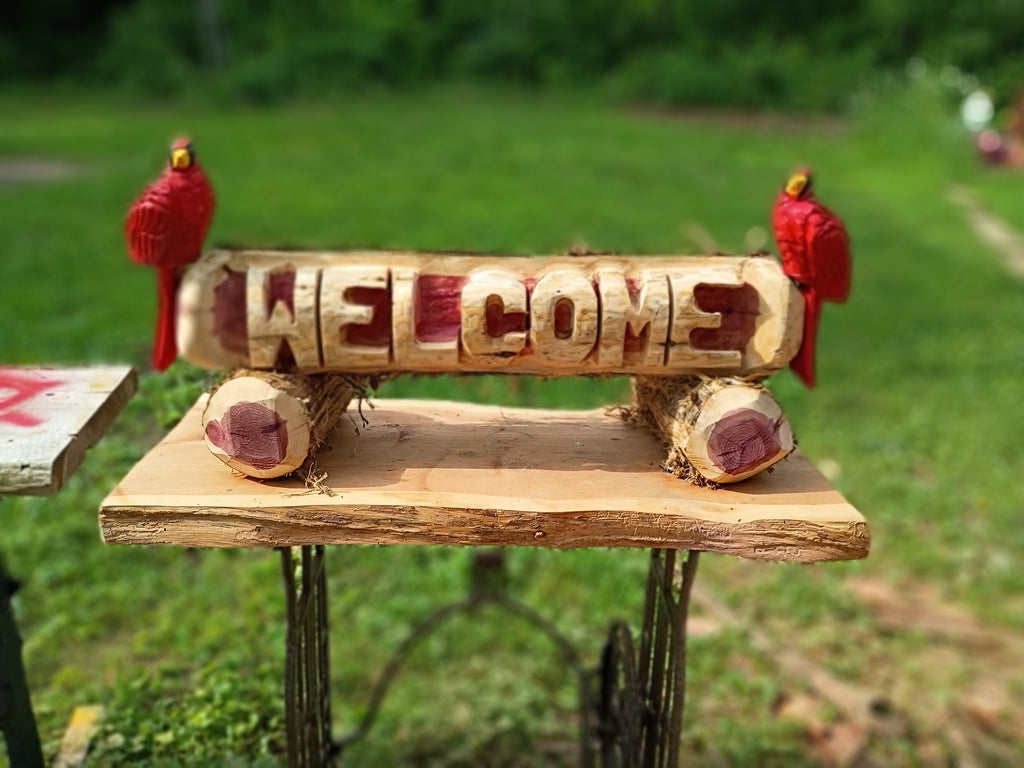 Welcome log with (2) Cardinal Birds