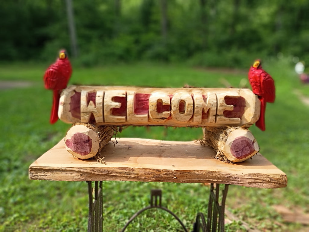 Welcome log with (2) Cardinal Birds